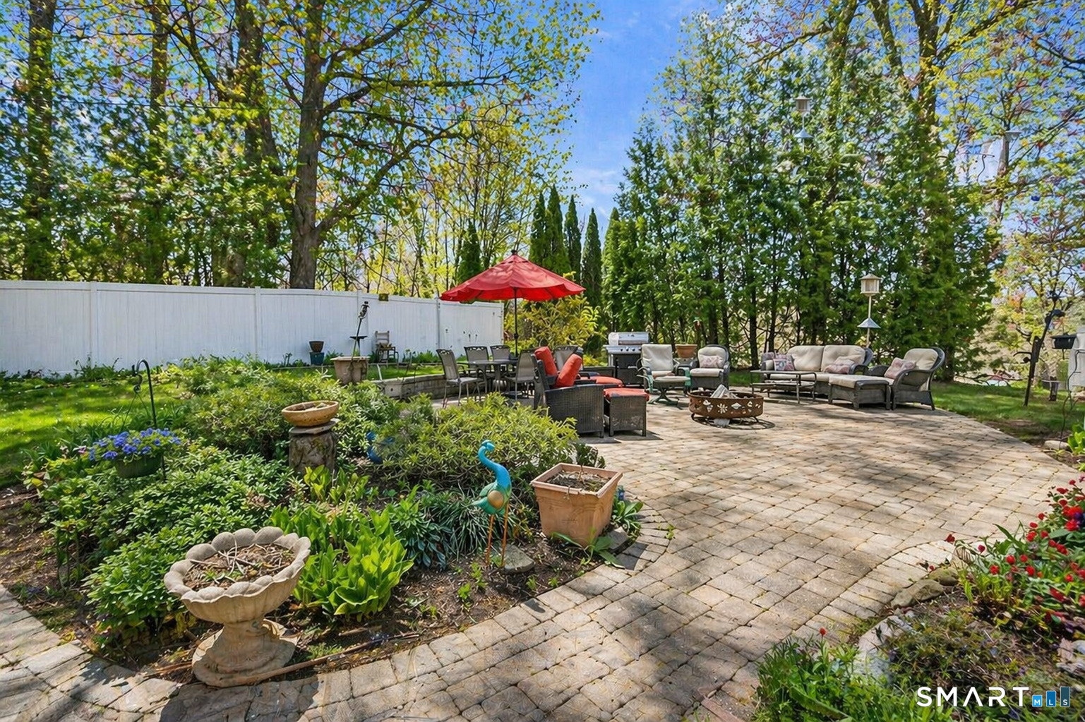 53 Cedar Street Middlefield, CT 06481 - Photo 24 of 30 Spacious paver patio designed for entertaining, featuring multiple seating areas, dining space, and lush garden surroundings.