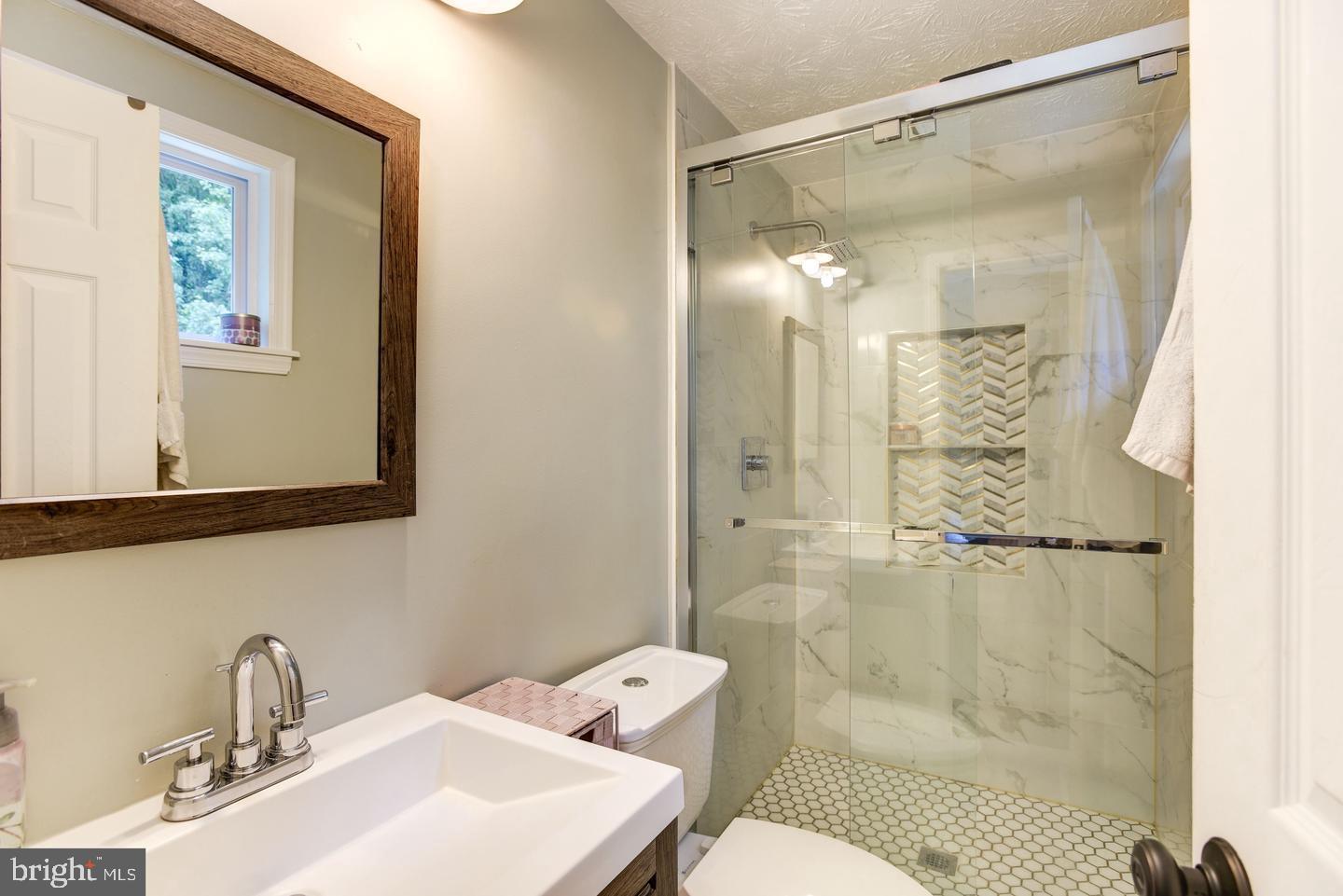 7310 Torran Rocks Way Gaithersburg, MD 20879 - Photo 15 of 32 a bathroom with a sink mirror toilet and shower