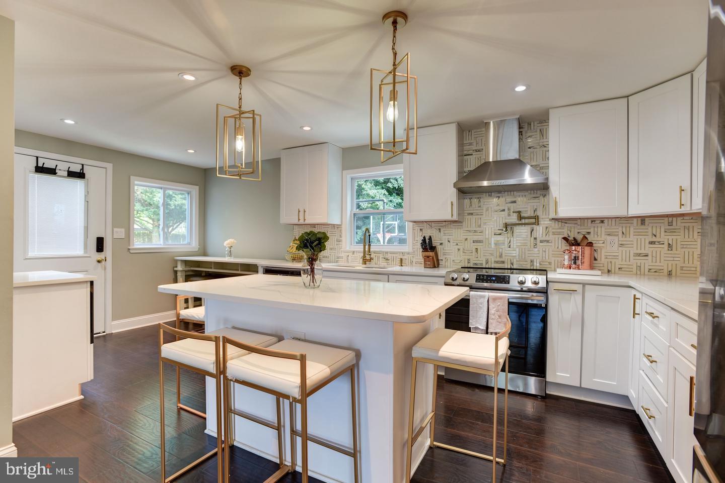 7310 Torran Rocks Way Gaithersburg, MD 20879 - Photo 6 of 32 a kitchen with stainless steel appliances kitchen island a table chairs sink and cabinets