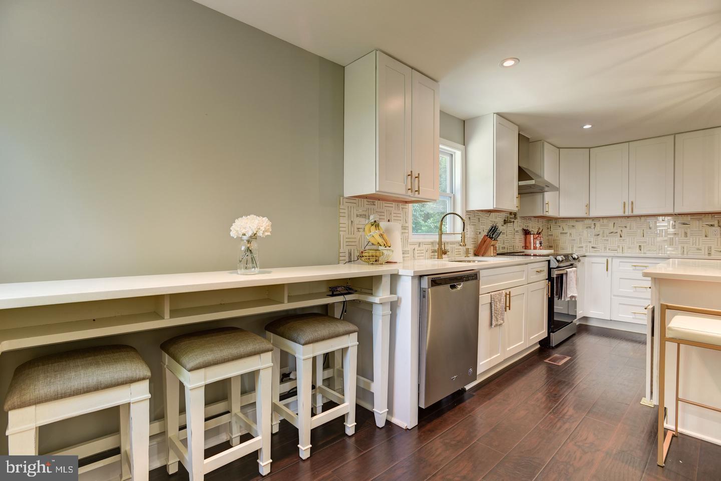 7310 Torran Rocks Way Gaithersburg, MD 20879 - Photo 9 of 32 a kitchen with a stove a sink and white cabinets with wooden floor