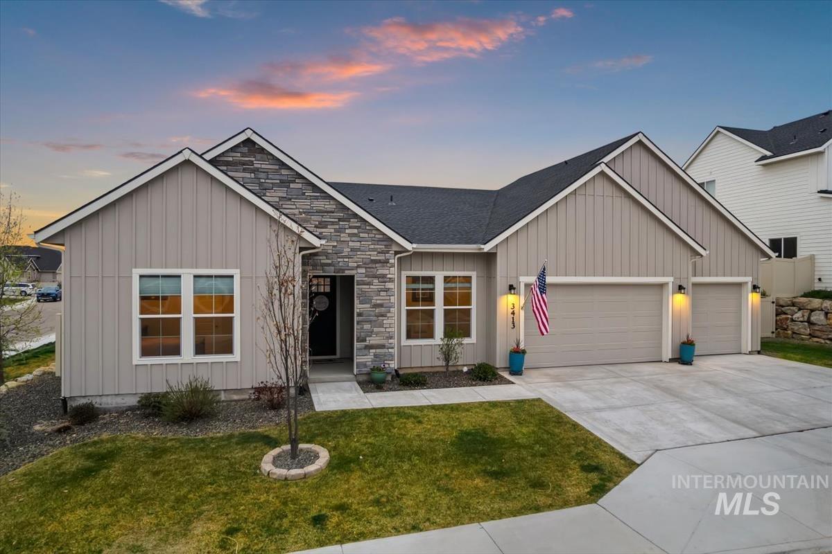 3413 North Hosta Avenue Star, ID 83669 - Photo 1 of 50 View of front of home with a garage, stone siding, driveway, board and batten siding, and a lawn