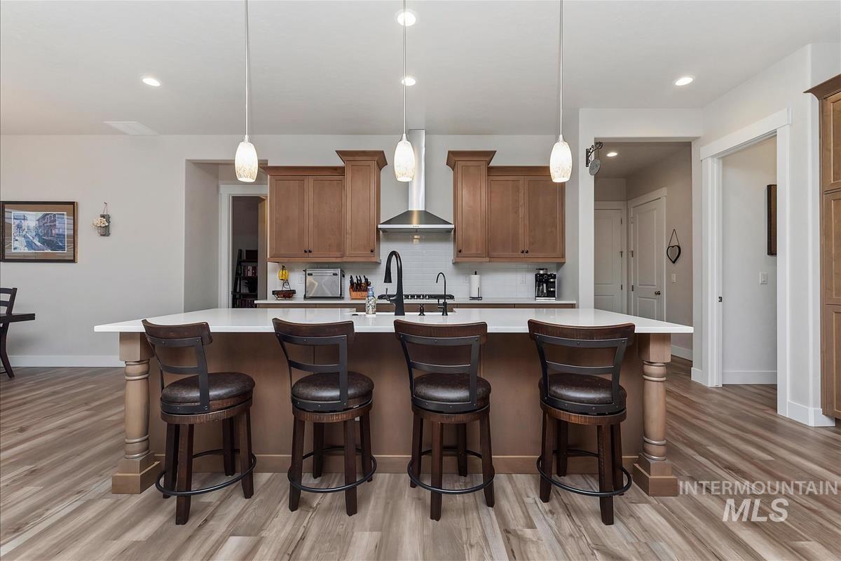 3413 North Hosta Avenue Star, ID 83669 - Photo 8 of 50 Kitchen featuring a spacious island, wood finish cabinets, backsplash, and a breakfast bar area
