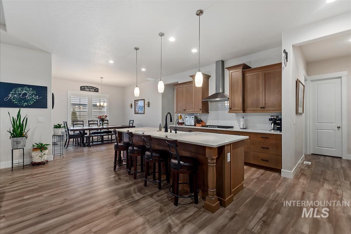 3413 North Hosta Avenue Star, ID 83669 - Photo 9 of 50 Kitchen with an island with sink, a kitchen bar, hanging light fixtures, backsplash, and dark wood-type flooring