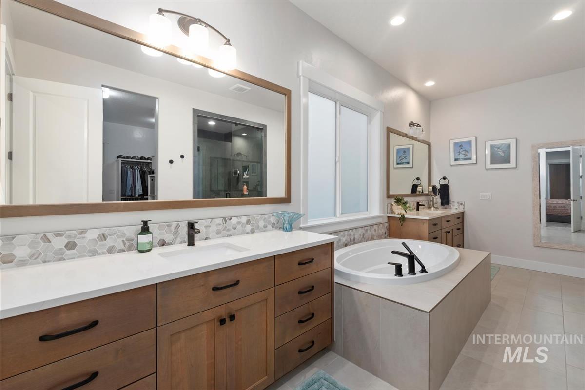 3413 North Hosta Avenue Star, ID 83669 - Photo 15 of 50 Full bathroom with a spacious closet, two vanities, a bath, a stall shower, and light tile patterned floors