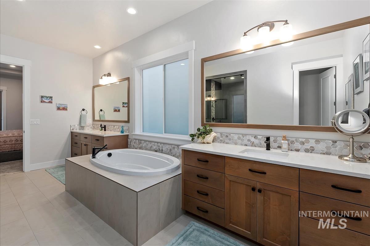 3413 North Hosta Avenue Star, ID 83669 - Photo 16 of 50 Bathroom with two vanities, a garden tub, light tile patterned floors, recessed lighting, and connected bathroom