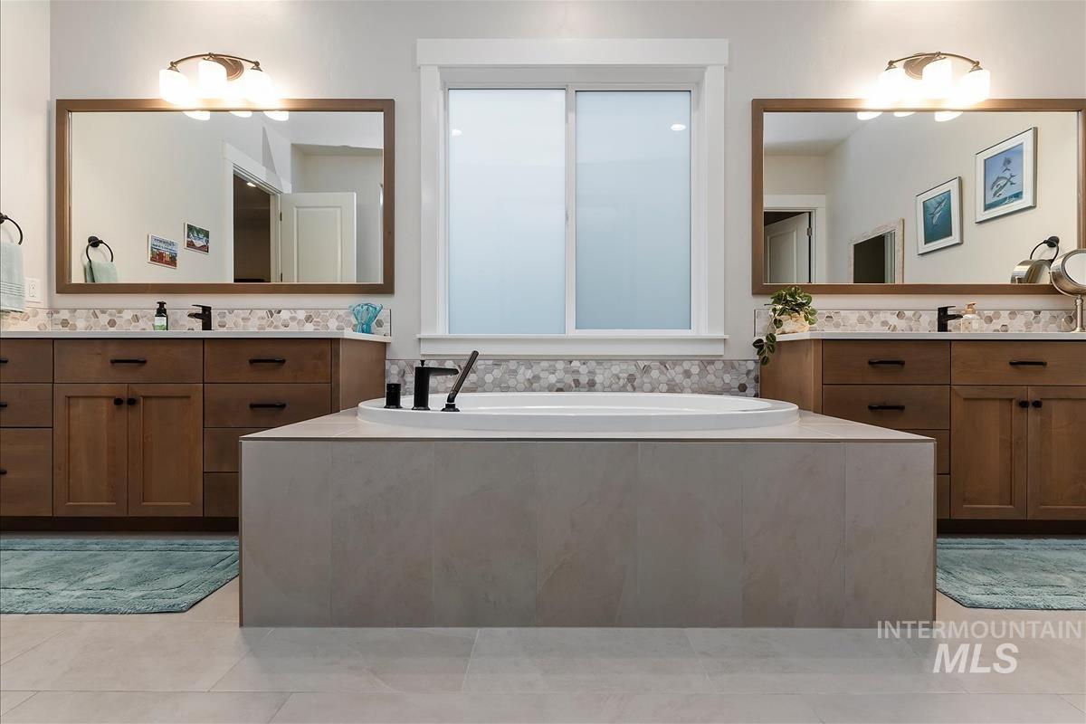 3413 North Hosta Avenue Star, ID 83669 - Photo 17 of 50 Full bathroom featuring two vanities, a bath, and light tile patterned flooring