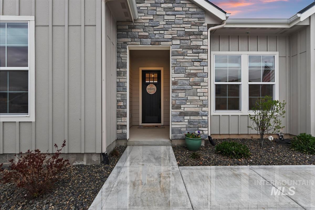 3413 North Hosta Avenue Star, ID 83669 - Photo 2 of 50 Exterior entry at dusk featuring board and batten siding and stone siding