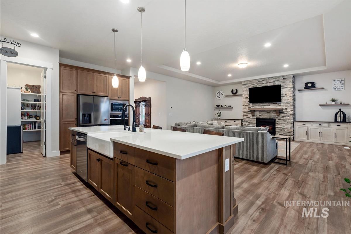 3413 North Hosta Avenue Star, ID 83669 - Photo 48 of 50 Kitchen with open floor plan, a tray ceiling, stainless steel appliances, light wood-style flooring, and a kitchen island with sink