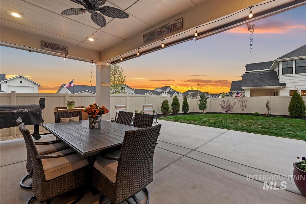 3413 North Hosta Avenue Star, ID 83669 - Photo 28 of 50 Patio terrace at dusk with ceiling fan, a patio area, a fenced backyard, outdoor dining area, and a residential view