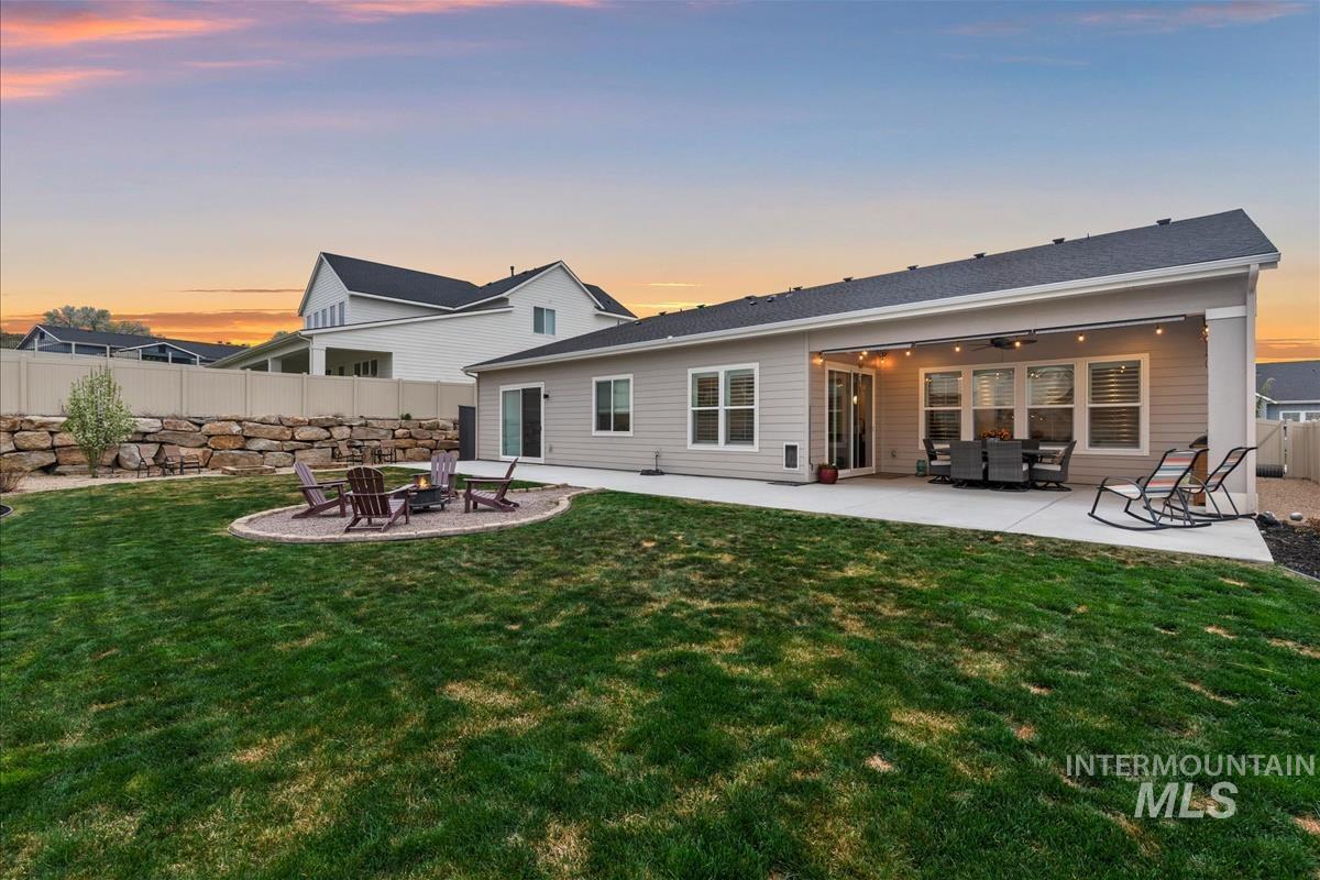 3413 North Hosta Avenue Star, ID 83669 - Photo 31 of 50 Rear view of house with a fenced backyard, a patio area, a ceiling fan, and an outdoor living space with a fire pit