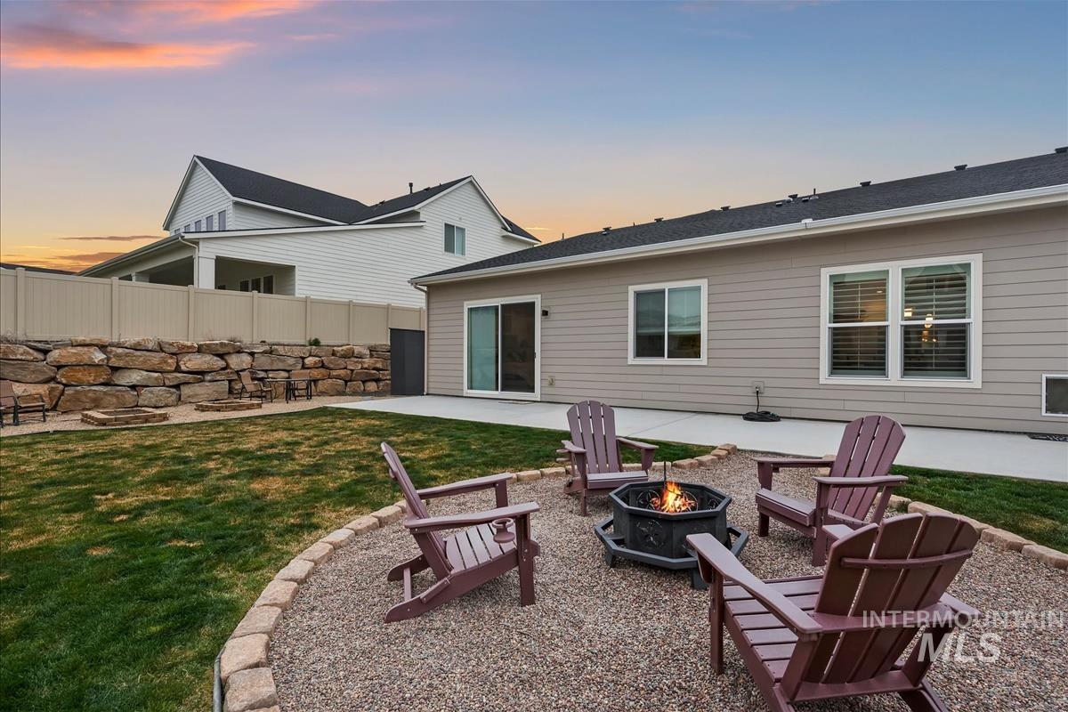 3413 North Hosta Avenue Star, ID 83669 - Photo 32 of 50 Back of property at dusk with a patio, an outdoor fire pit, and a shingled roof