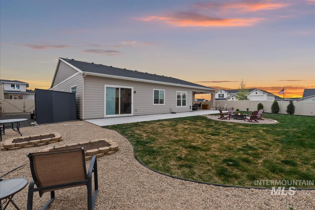 3413 North Hosta Avenue Star, ID 83669 - Photo 35 of 50 Back of property at dusk featuring a fire pit, a patio, and a fenced backyard