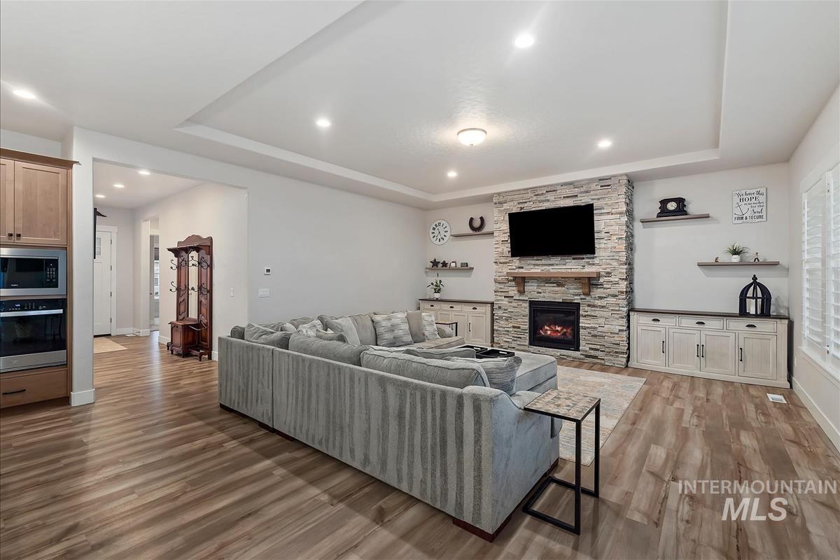 3413 North Hosta Avenue Star, ID 83669 - Photo 3 of 50 Living room featuring a raised ceiling, light wood-style flooring, and a fireplace