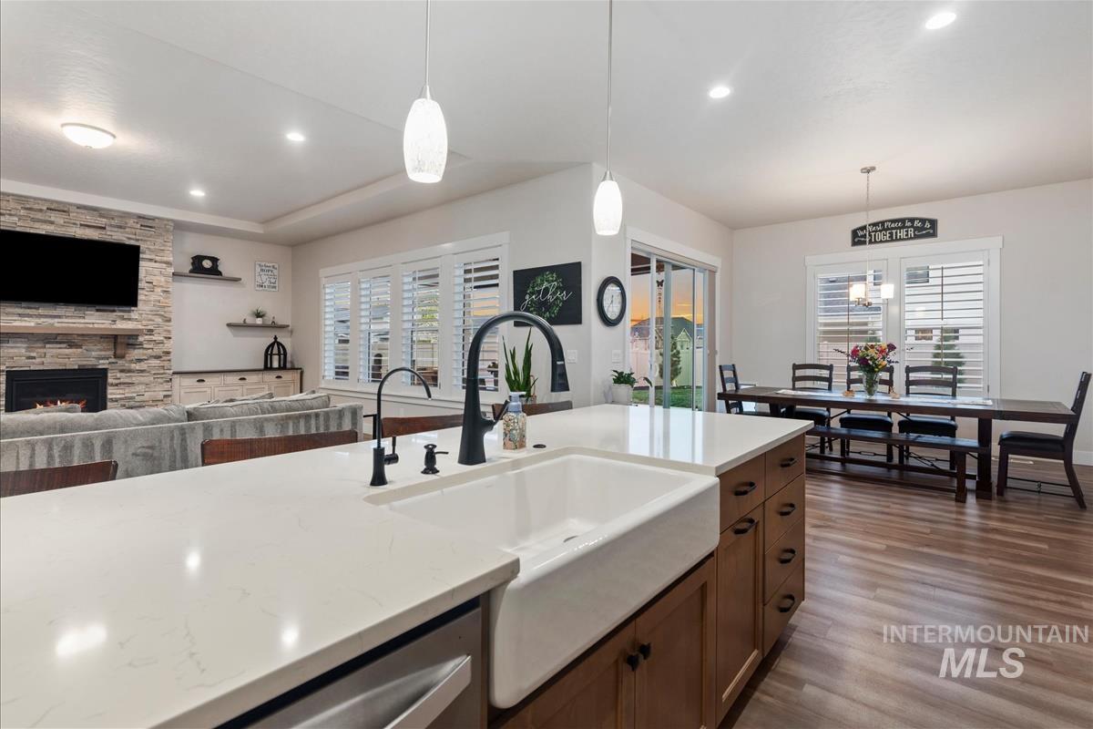 3413 North Hosta Avenue Star, ID 83669 - Photo 50 of 50 Kitchen with open floor plan, dark wood-type flooring, hanging light fixtures, a stone fireplace, and light stone countertops