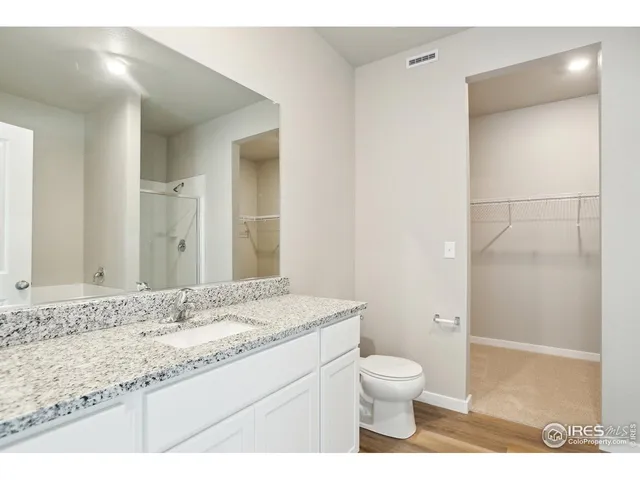 a bathroom with a granite countertop sink toilet a mirror and a shower
