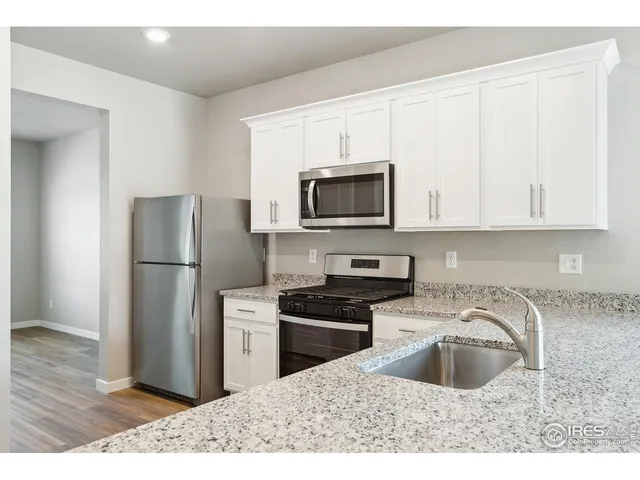 a kitchen with a sink a stove a microwave and refrigerator