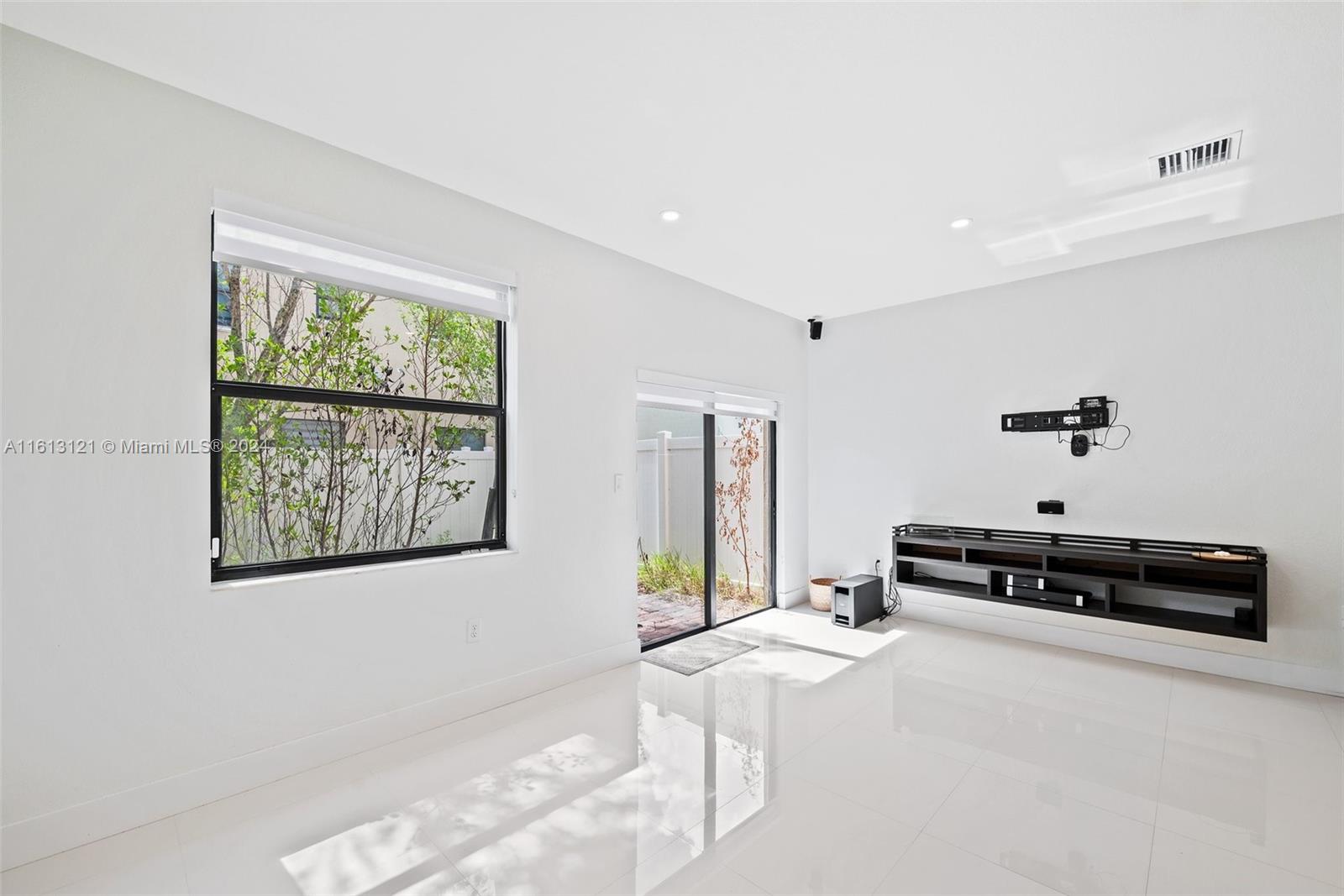 9361 West 33rd Way Hialeah, FL 33018 - Photo 14 of 30 a spacious bedroom with a bed a couch and a window