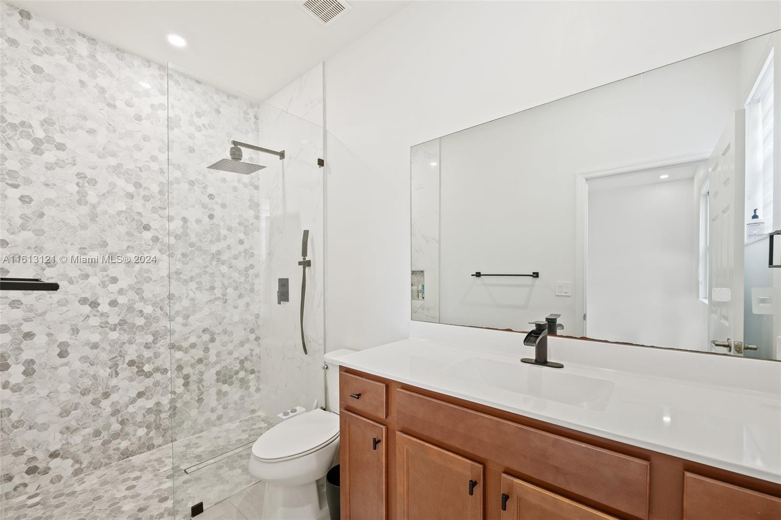 9361 West 33rd Way Hialeah, FL 33018 - Photo 19 of 30 a bathroom with a granite countertop sink a toilet and a mirror