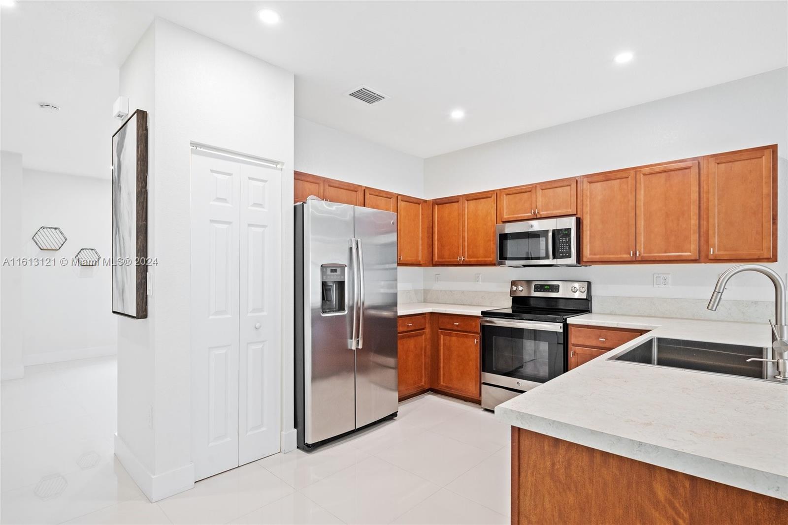 9361 West 33rd Way Hialeah, FL 33018 - Photo 9 of 30 a kitchen with stainless steel appliances granite countertop a refrigerator a stove top oven a sink and dishwasher