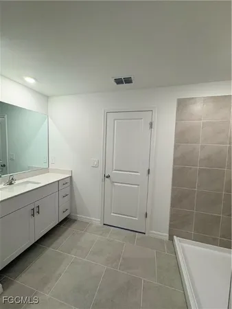 a large bathroom with a double vanity sink a toilet and a bathtub