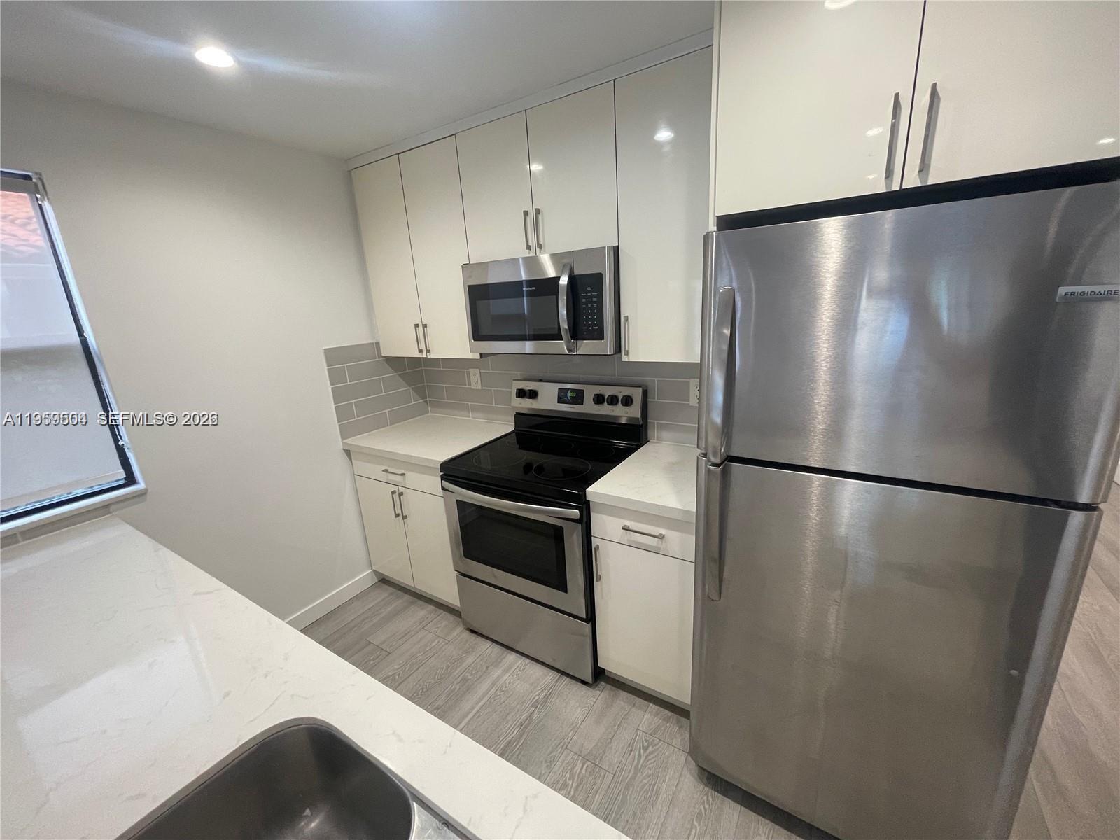 1637 Southwest 10th Street, Unit 2 Miami, FL 33135 - Photo 4 of 9 a kitchen with a refrigerator a stove and a sink
