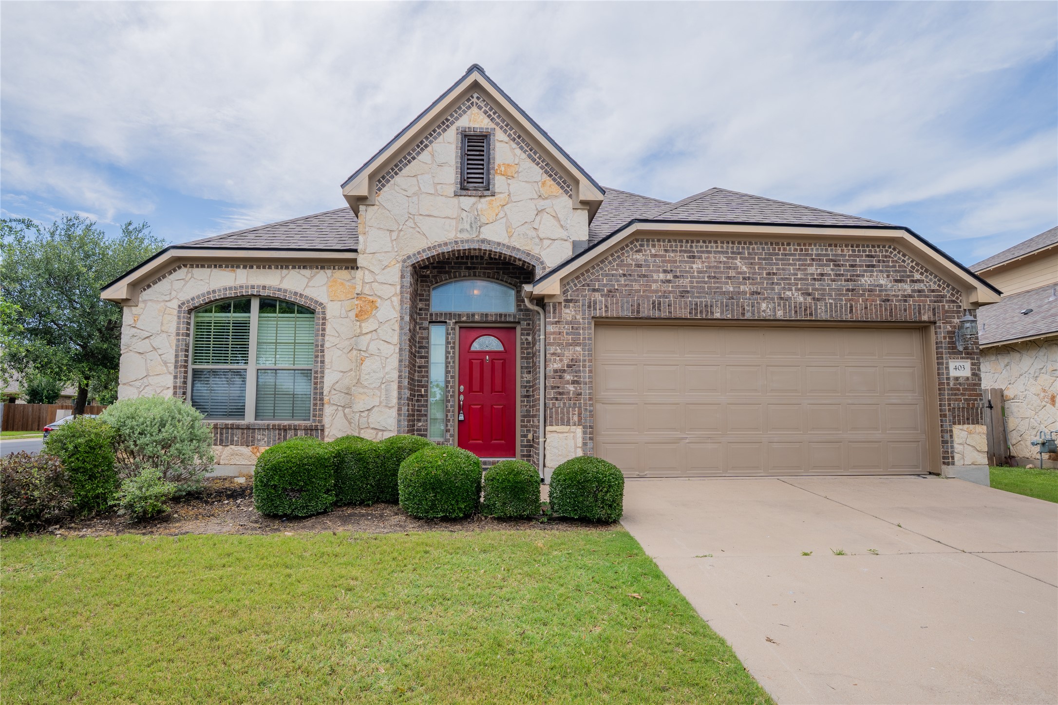 403 Tascate Street Georgetown, TX 78628 - Photo 1 of 26 A welcoming front exterior showcasing attractive stonework and a bold entry.