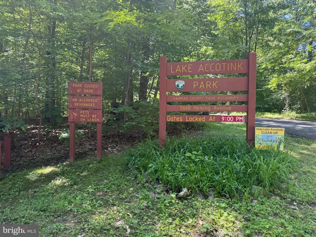 a sign board with a house in the background