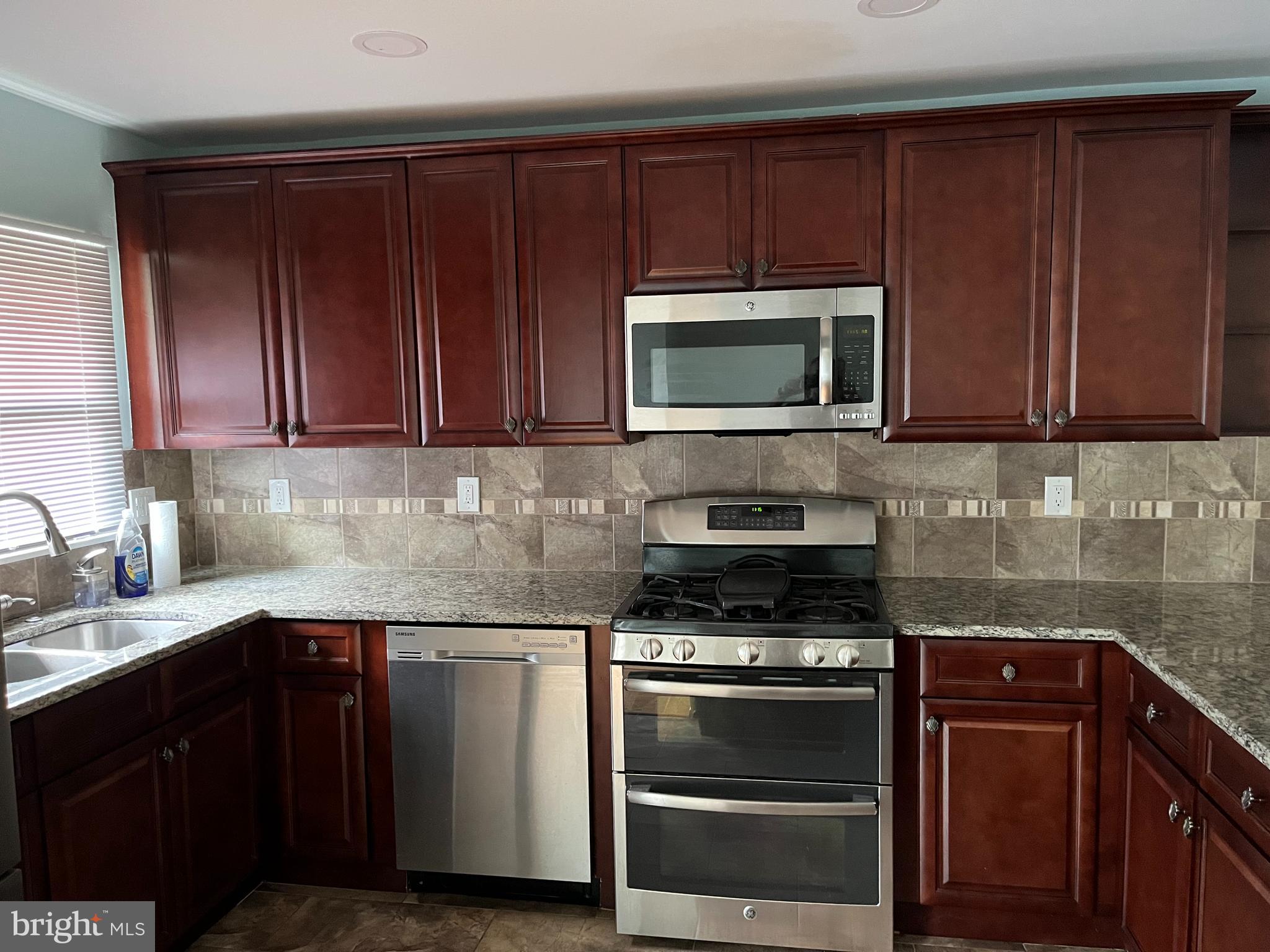 5608 Heming Avenue Springfield, VA 22151 - Photo 4 of 26 a kitchen with granite countertop wood cabinets and stainless steel appliances