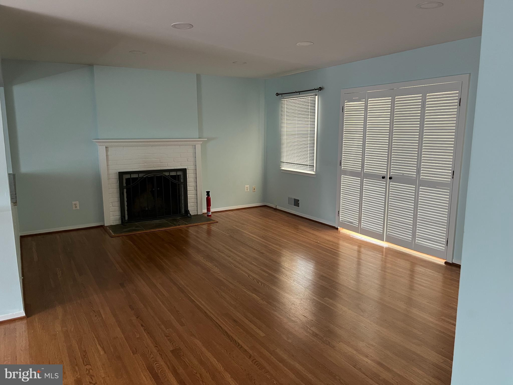 5608 Heming Avenue Springfield, VA 22151 - Photo 6 of 26 an empty room with wooden floor fireplace and windows