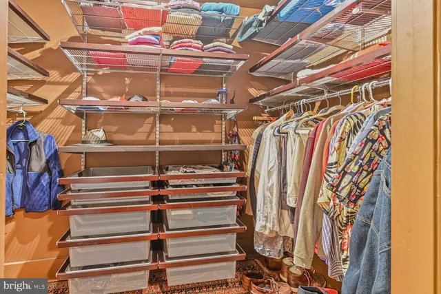 a view of walk in closet with clothes and shoes