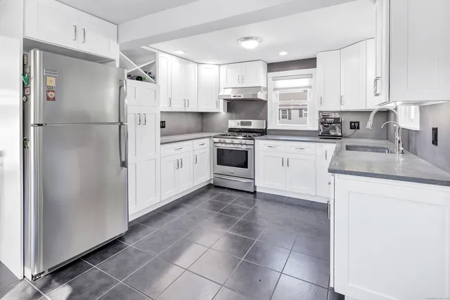 a kitchen with stainless steel appliances granite countertop a refrigerator sink and cabinets