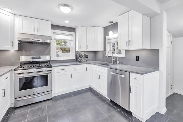 a kitchen with cabinets appliances a sink and a window