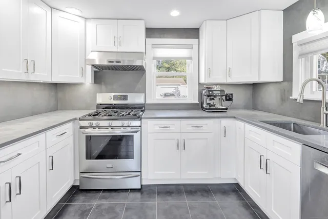 a kitchen with white cabinets and white appliances