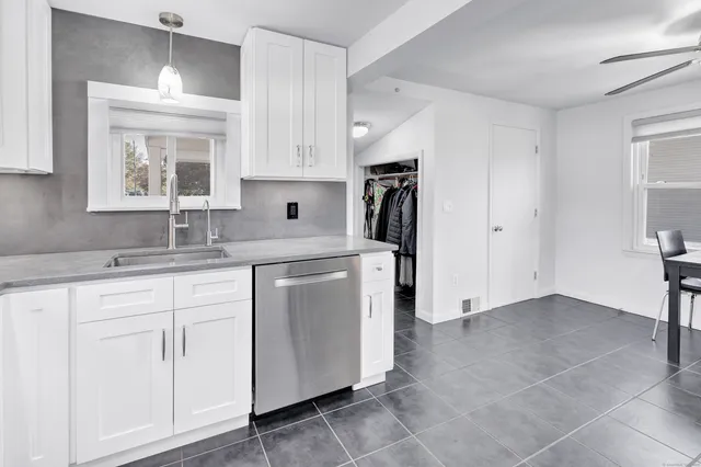 a kitchen with stainless steel appliances granite countertop a sink and a refrigerator