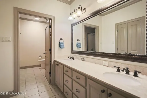 a bathroom with a double vanity sink and mirror with shower