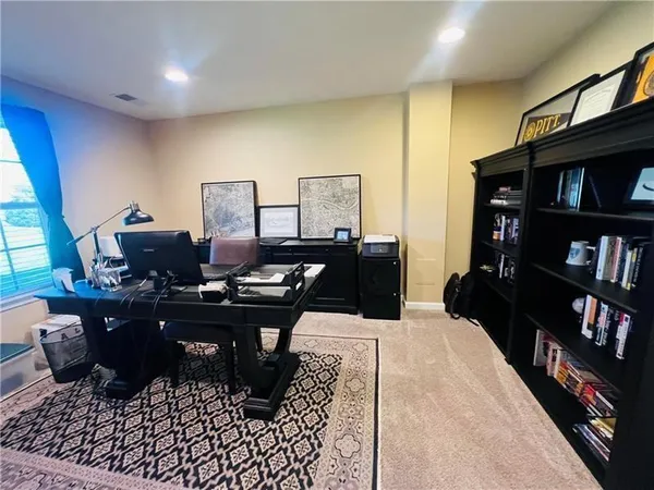 a living room with furniture a piano and a bookshelf