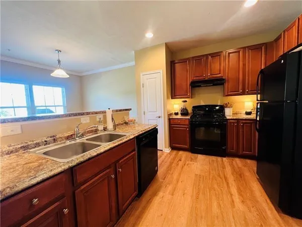 a kitchen with a sink wooden floor cabinets and appliances
