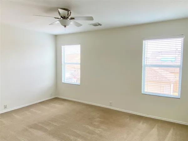 an empty room with a window and a fan