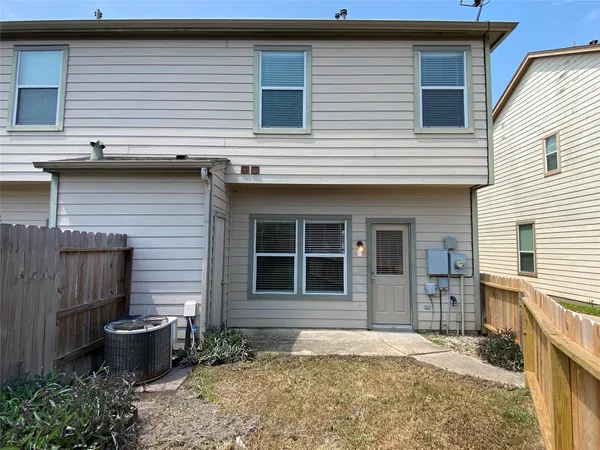 a backyard of a house with outdoor seating and barbeque oven