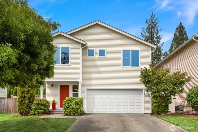 a front view of a house with a yard and garage