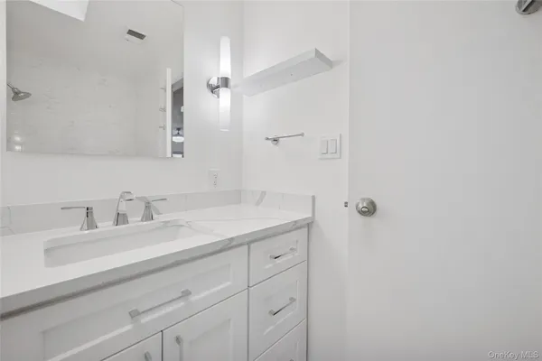 a bathroom with a granite countertop sink and a mirror