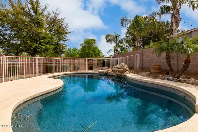a view of a swimming pool with a yard and sitting area