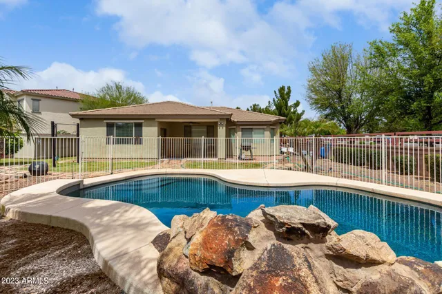 a view of a house with pool and chairs