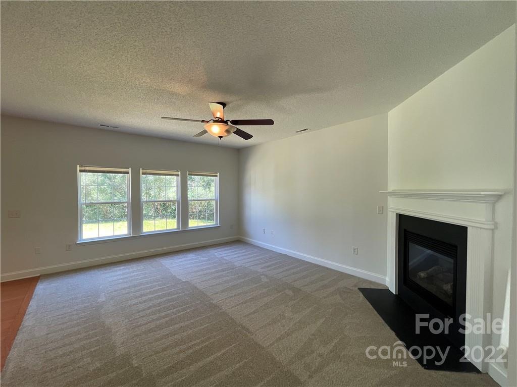 13712 Rutherglen Court Charlotte, NC 28213 - Photo 5 of 22 a view of an empty room with a fireplace and a window