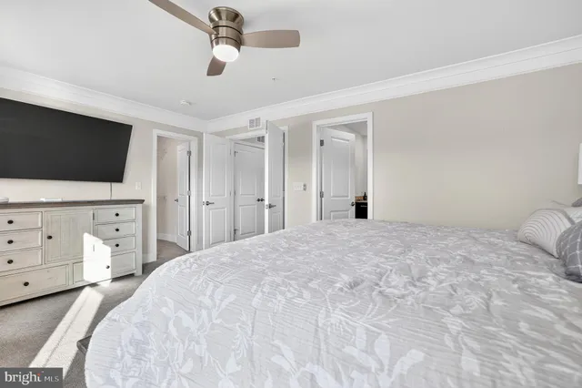 a bedroom with a bed a window and a flat screen tv