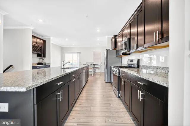 a large kitchen with granite countertop lots of counter space and stainless steel appliances