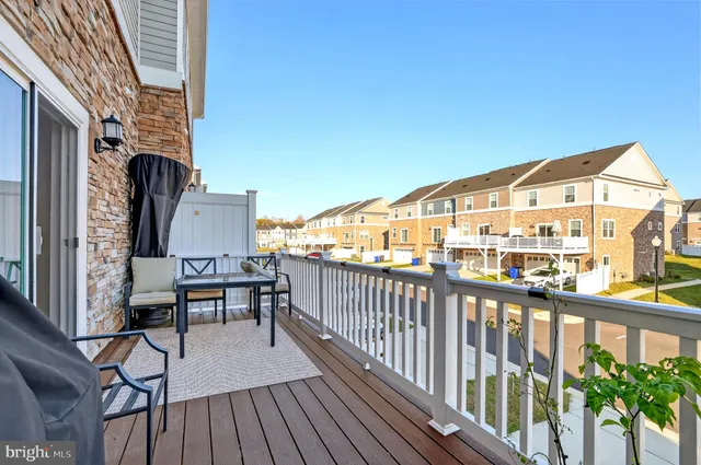 a view of a balcony with chairs and wooden fence