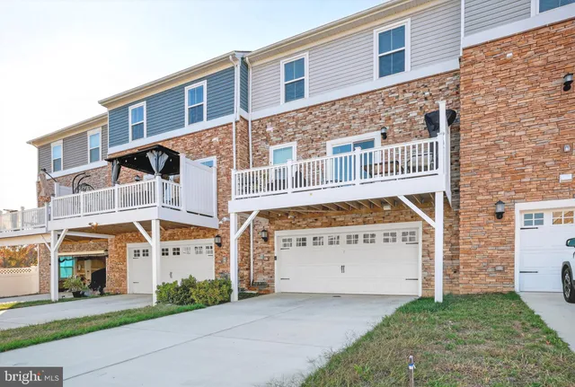 a view of a building with a small yard and large tree