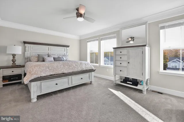 a bedroom with a bed and large windows