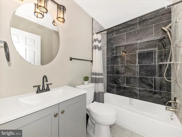 a bathroom with a sink mirror toilet and bathtub